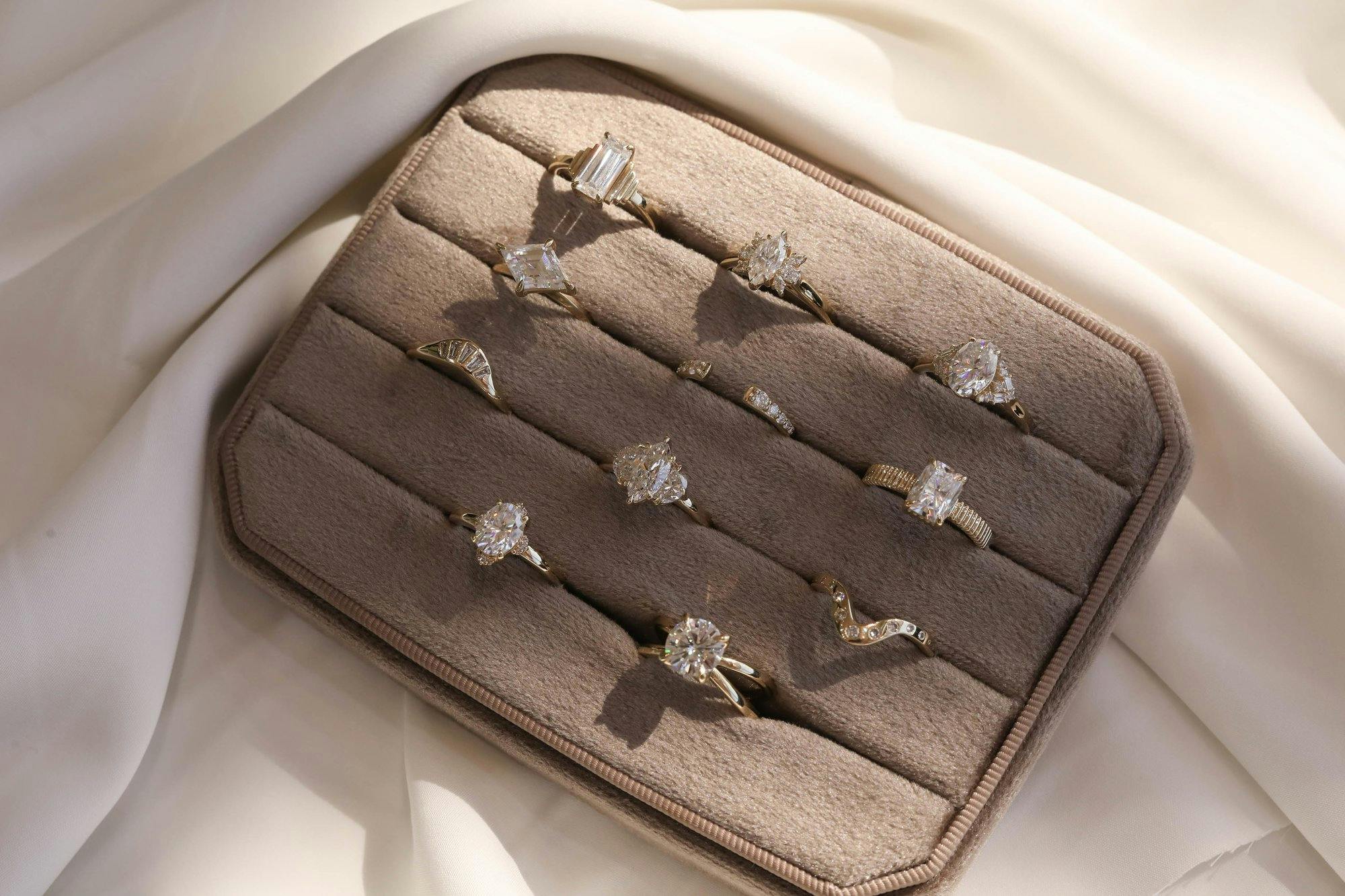 a group shot of diamond engagement rings in a ring box.