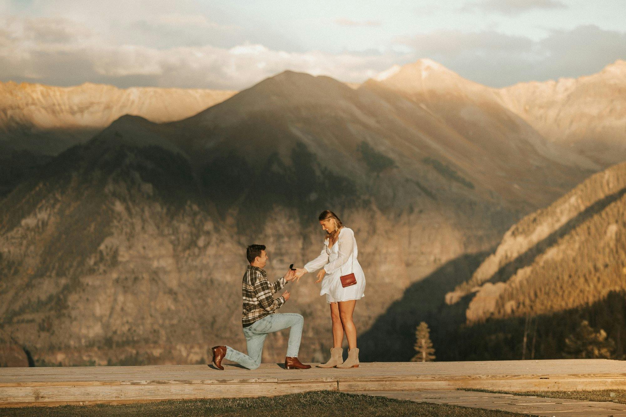a couple getting engaged at a scenic mountain