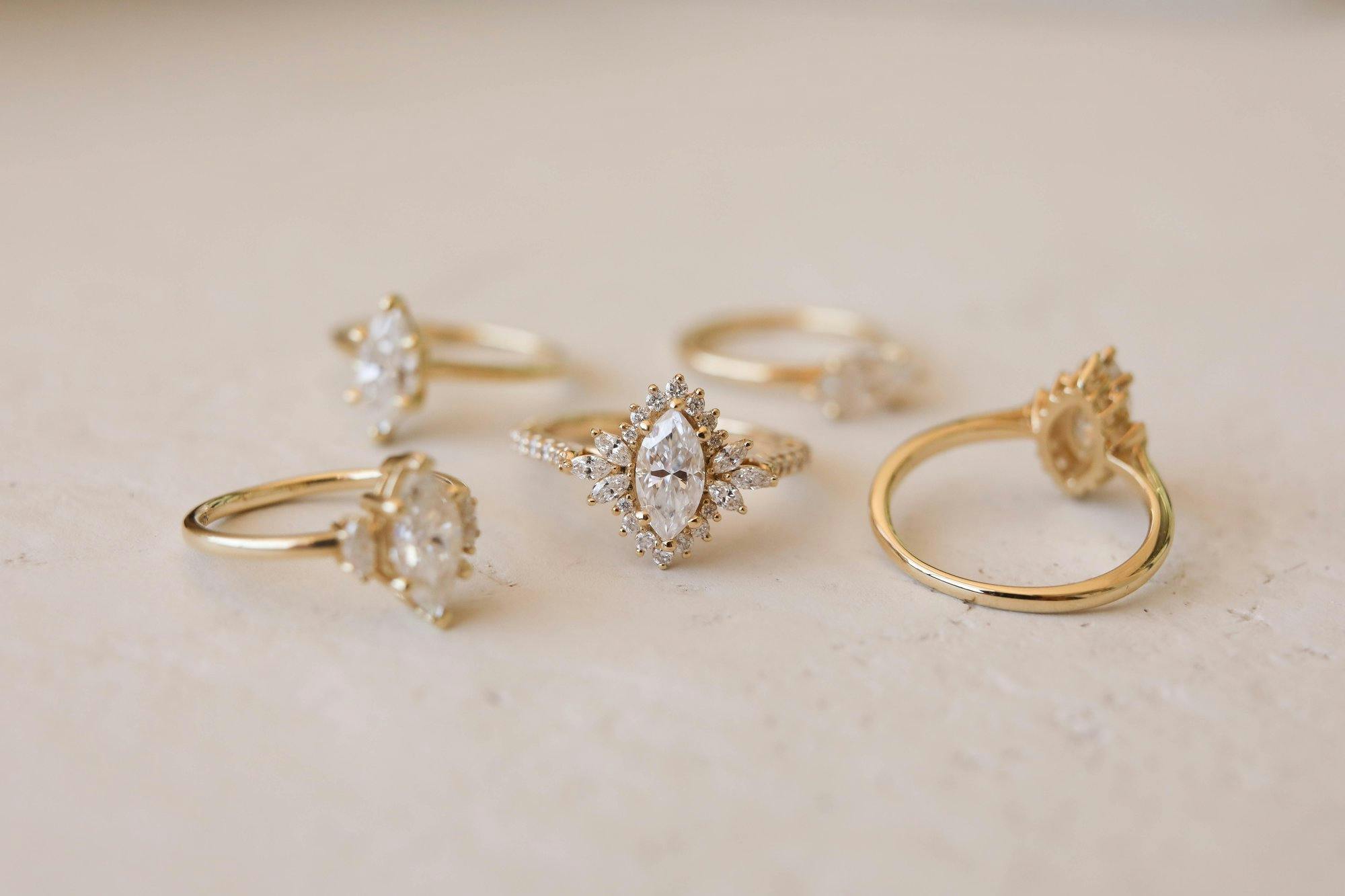 group photo of yellow gold, marquise, engagement rings with moissanite center stones