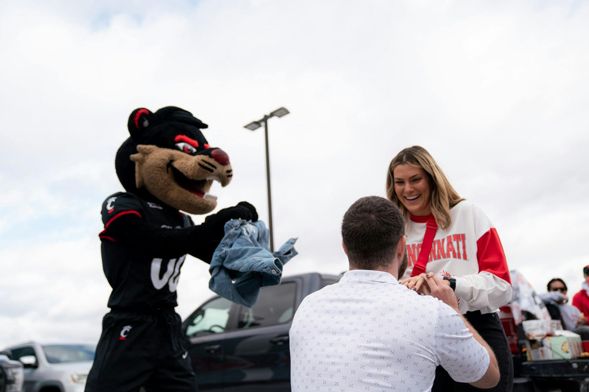 a couple getting engaged at a university of Cincinnati game 